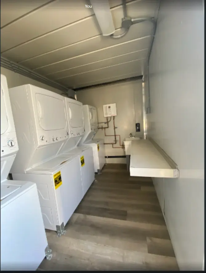 Row of stacked washers and dryers in a laundry container