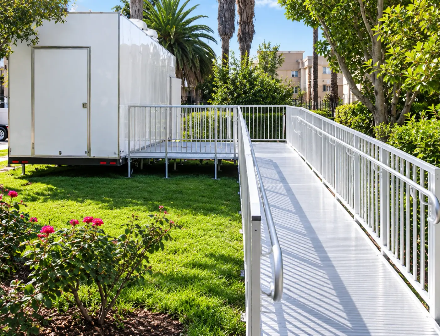 Aluminum access ramp with handrails leading to a trailer door