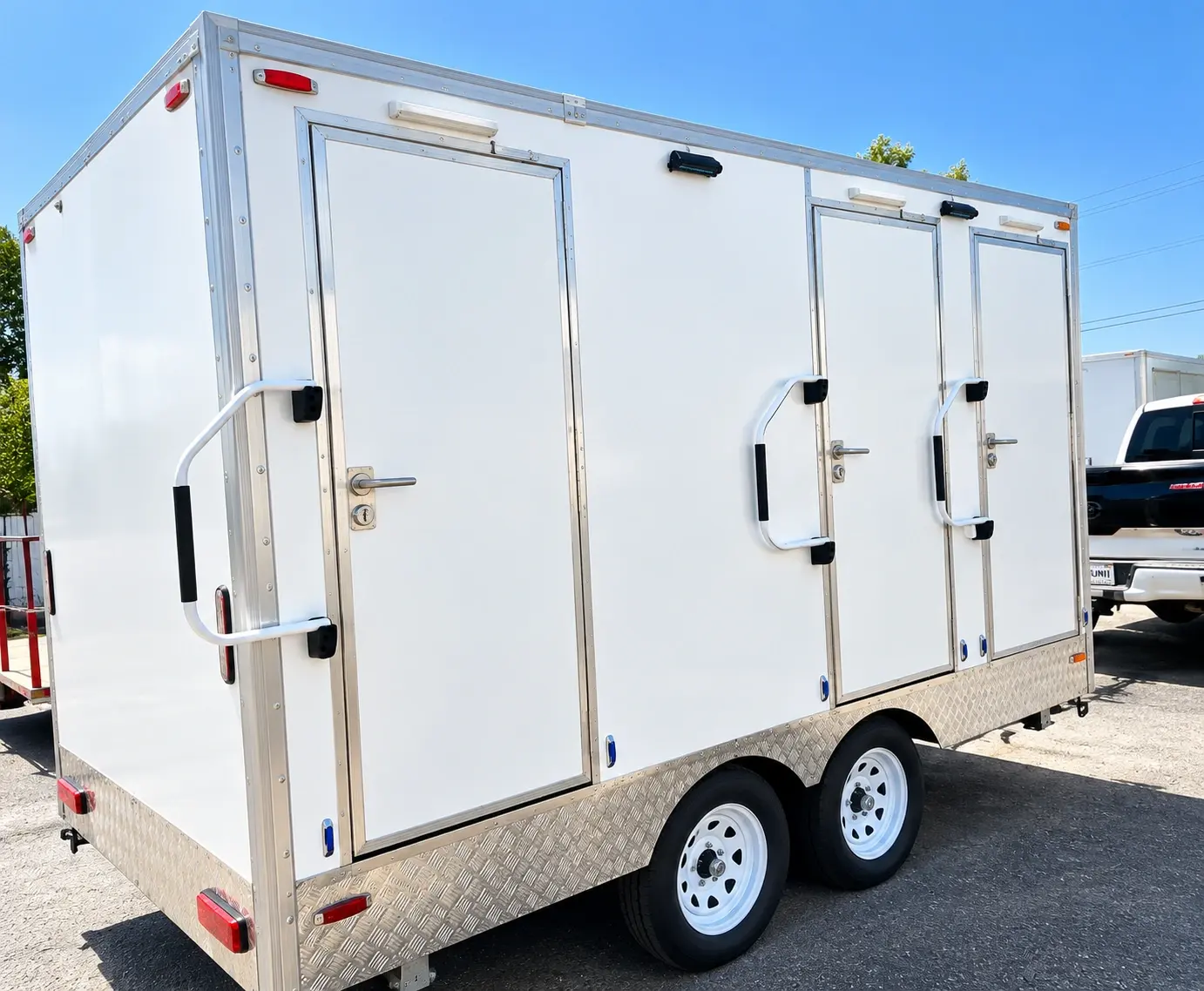 Side of a 13ft shower and restroom combination trailer with individual stall doors