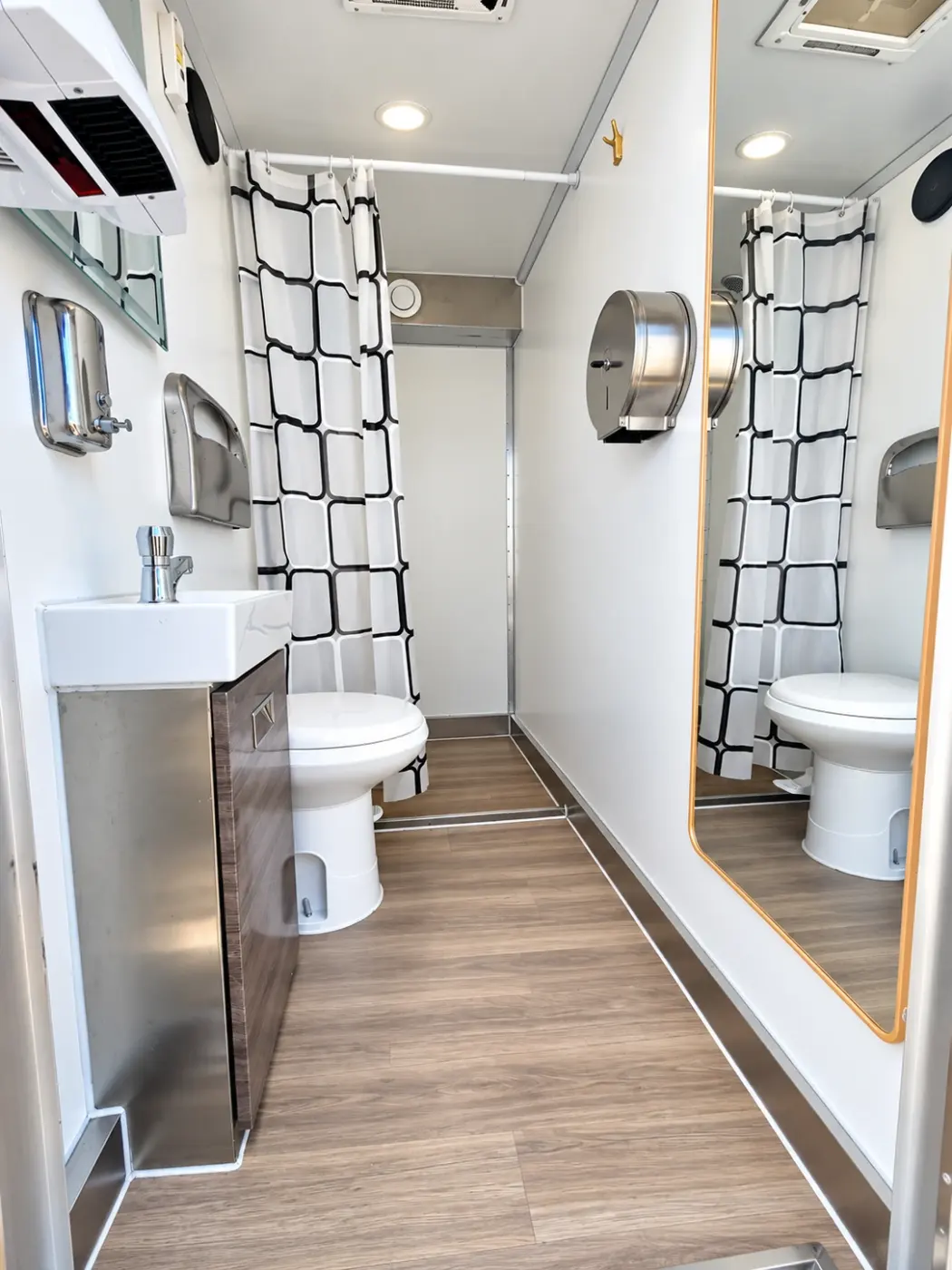 Inside a shower and restroom stall with toilet, sink and shower